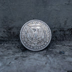 Morgan Dollar reverse showing the American eagle with spread wings, In God We Trust, United States of America, and One Dollar denomination on dark stone