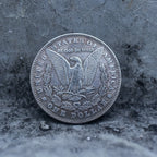 Morgan Dollar reverse showing the American eagle, In God We Trust inscription, and One Dollar denomination on a stone surface