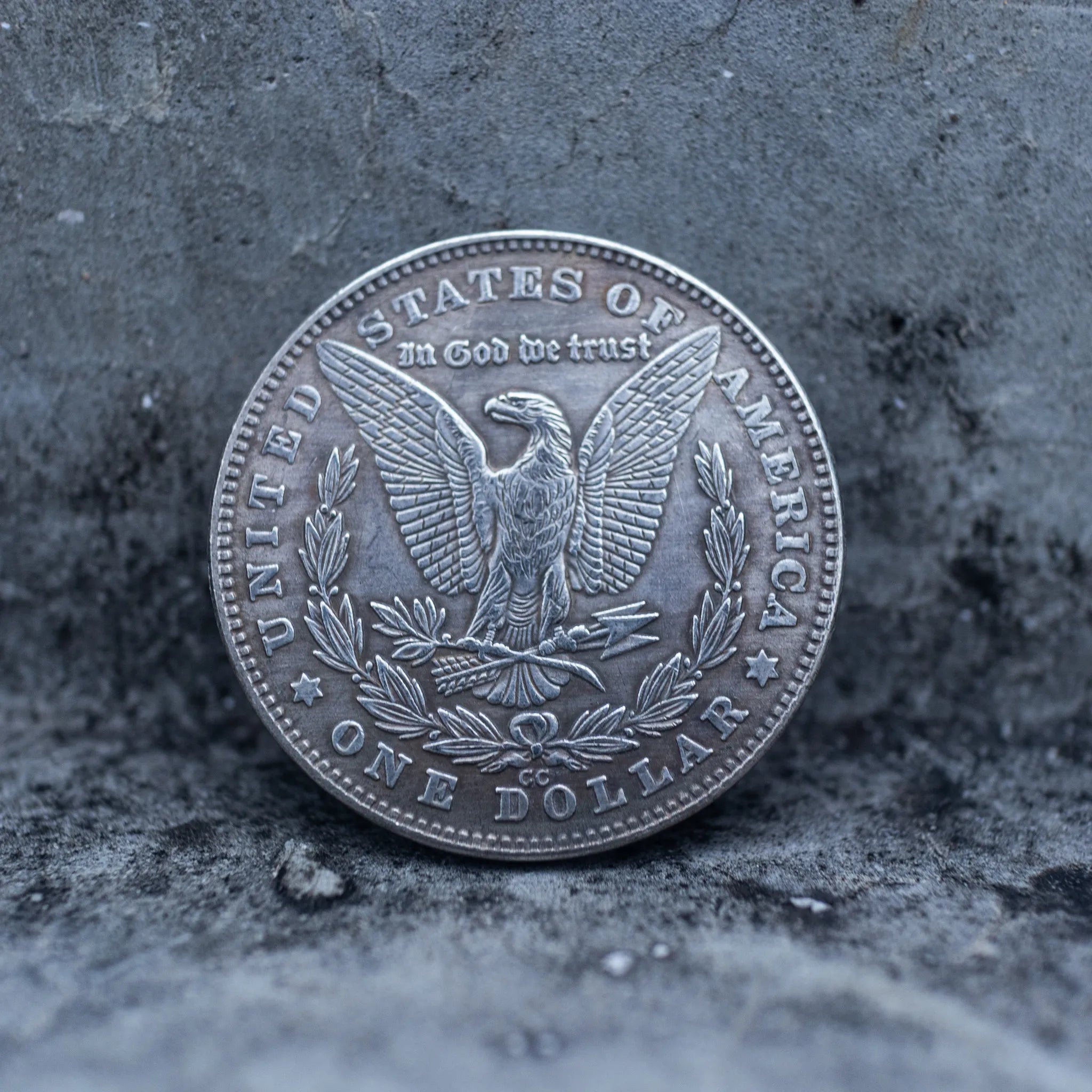 Morgan Dollar reverse showing the American eagle, In God We Trust inscription, and One Dollar denomination on a stone surface