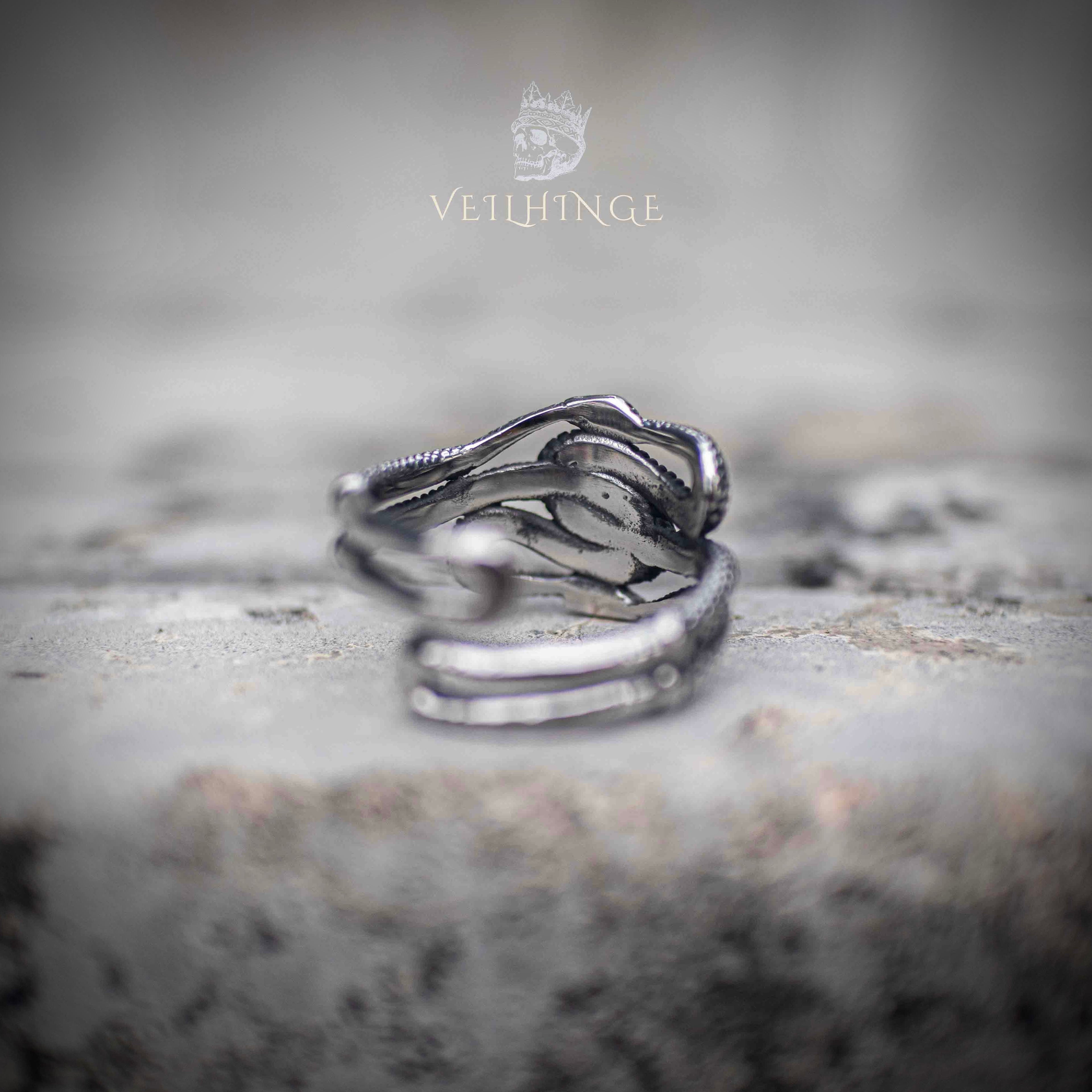 Side view of multi-snake open ring showing inner band construction and overlapping serpent scale texture — polished steel interior, adjustable open back