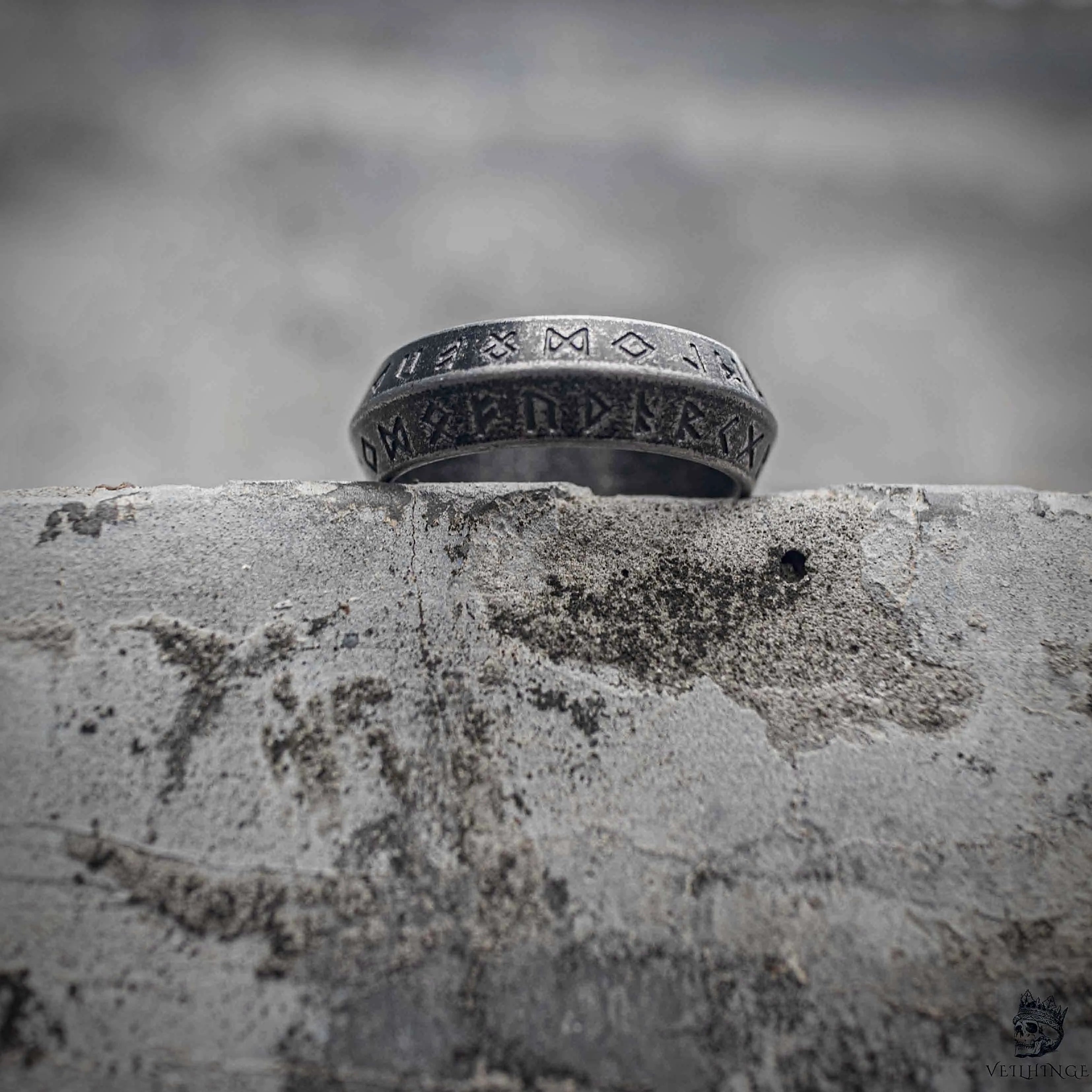 Norse rune ring showing double line Elder Futhark engraving and polished stainless steel interior, sandblasted silver Viking minimalist band ring by Veilhinge, angled view