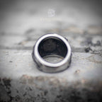 Inner band of serpent ring showing smooth brushed steel interior and maker's stamp — wide band construction, substantial weight