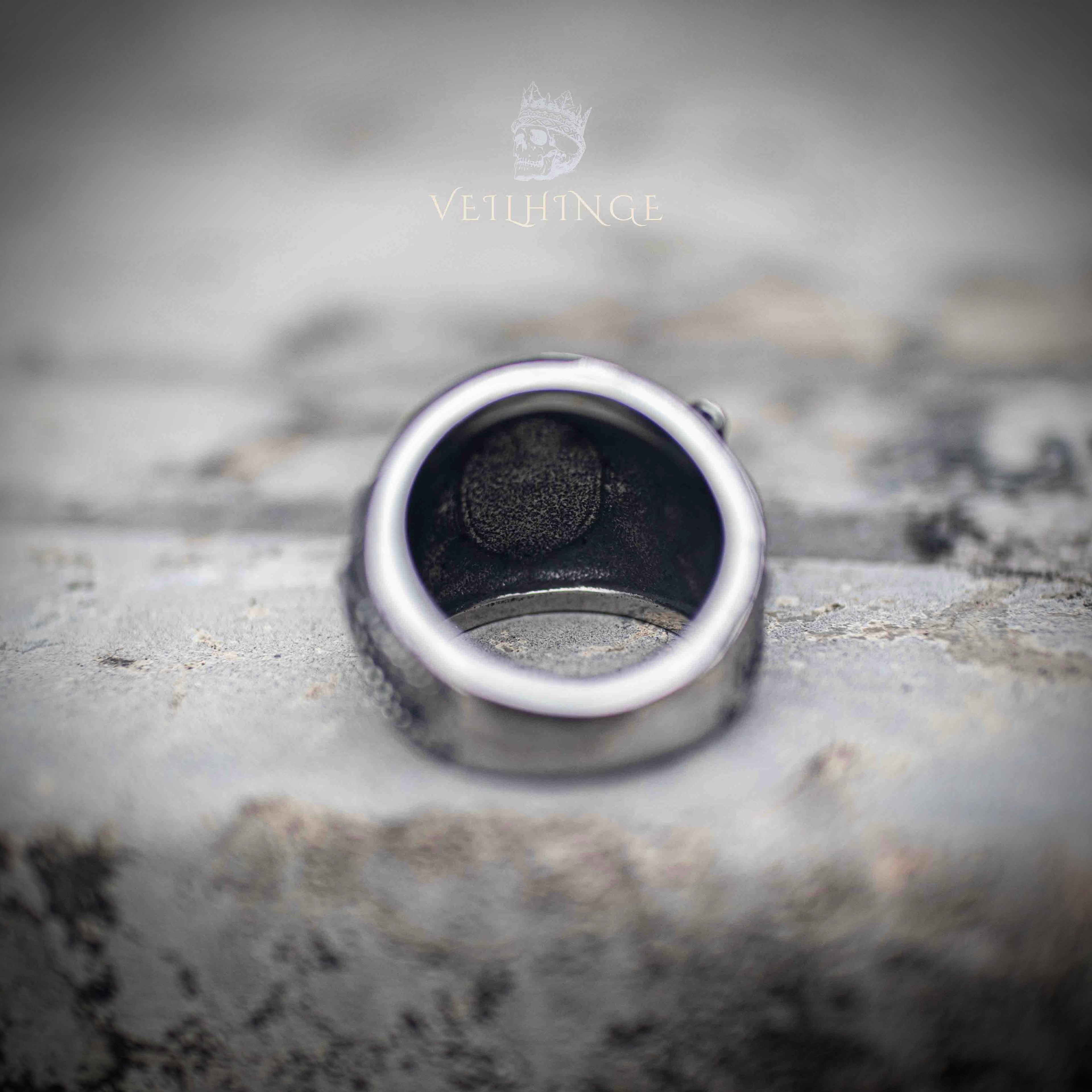 Inner band of serpent ring showing smooth brushed steel interior and maker's stamp — wide band construction, substantial weight