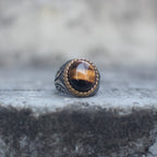 Oversized tiger eye signet ring with a gold-tone rope bezel, front view