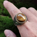 Oversized tiger eye signet ring worn on the hand in natural light