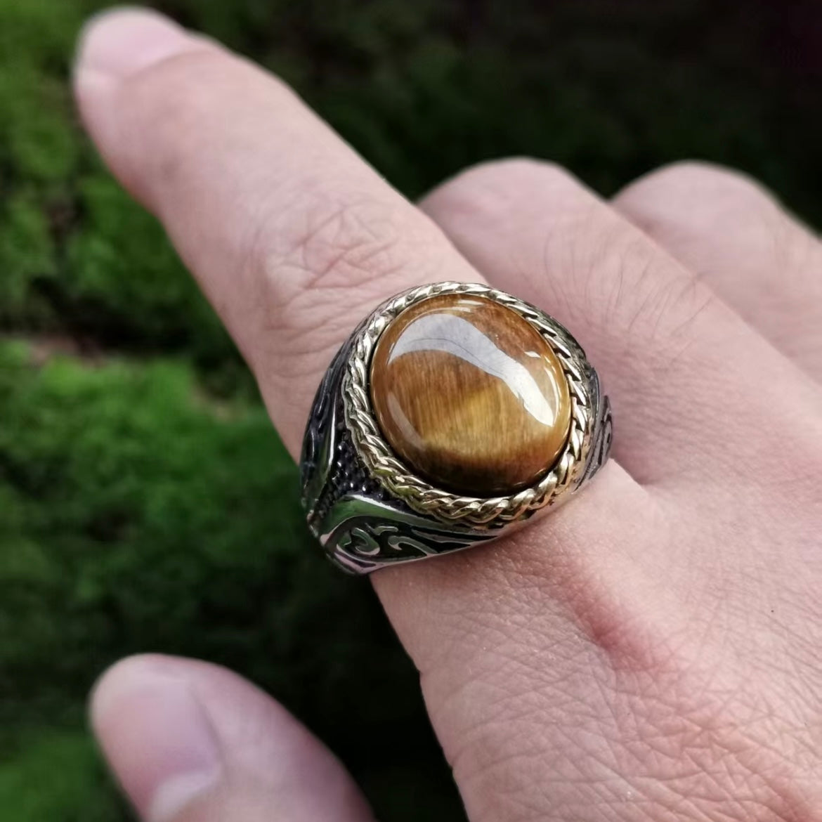 Oversized tiger eye signet ring worn on the hand in natural light