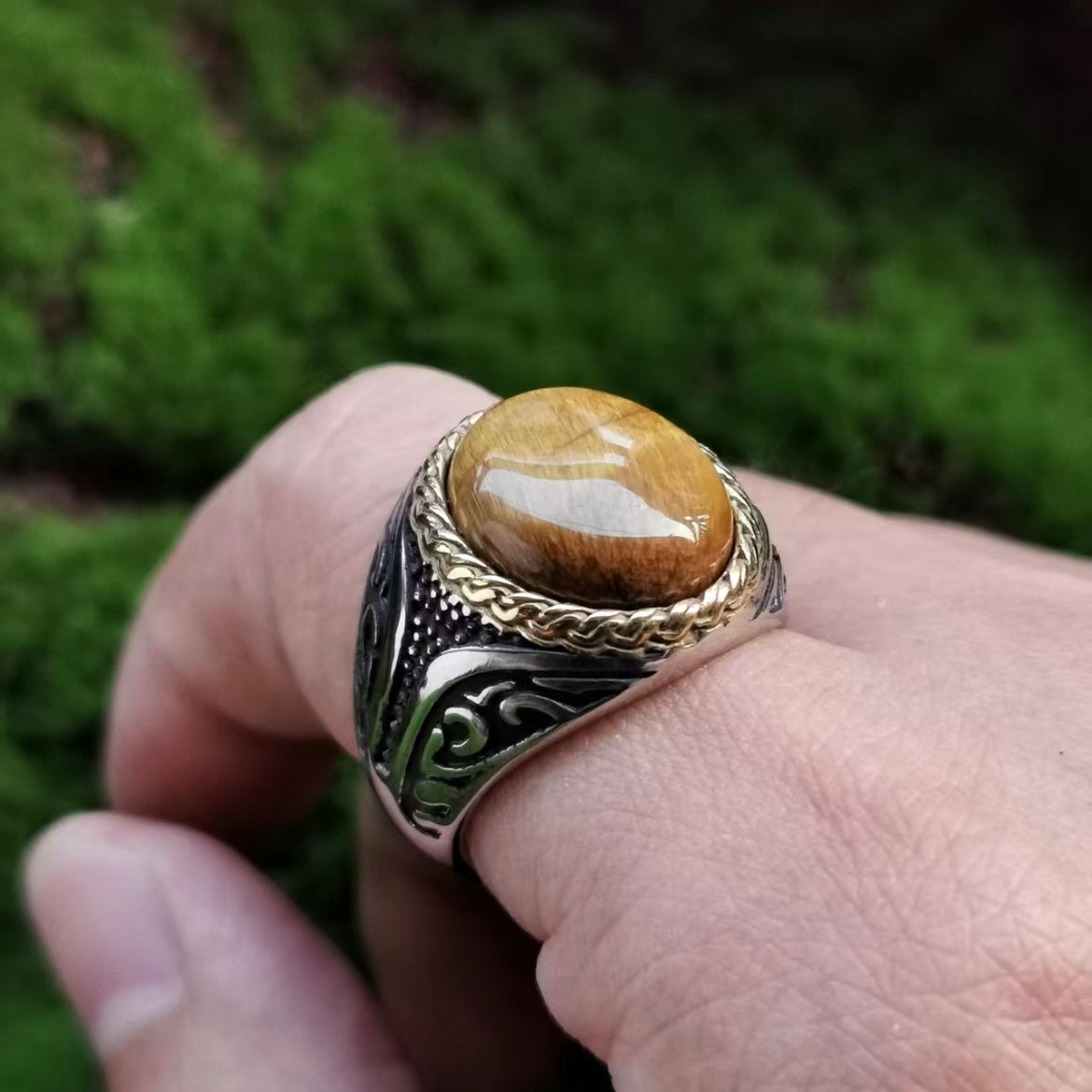 Side view of a large tiger eye signet ring worn on the finger