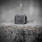 oxidized square signet ring with horizontal brushed texture — front view on concrete surface
