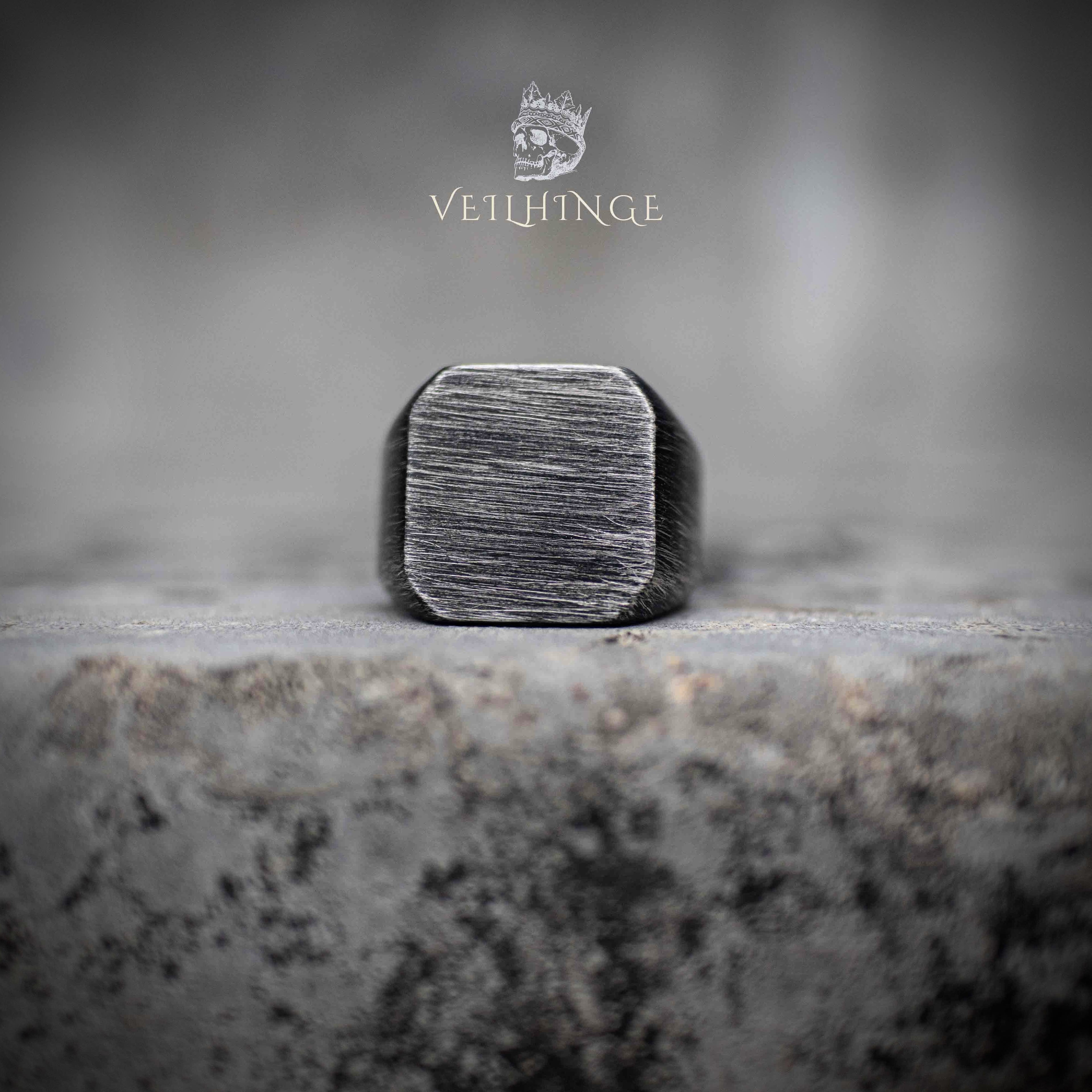 oxidized square signet ring with horizontal brushed texture — front view on concrete surface