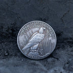 Peace Dollar reverse showing a standing eagle, E Pluribus Unum, United States of America, and Peace inscription at base on dark stone surface