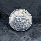 Close-up of a coin engraved with a bearded pirate captain skull in tricorn hat, compass badge on hat, Liberty inscription, dated 1913, ship wheel at lower right