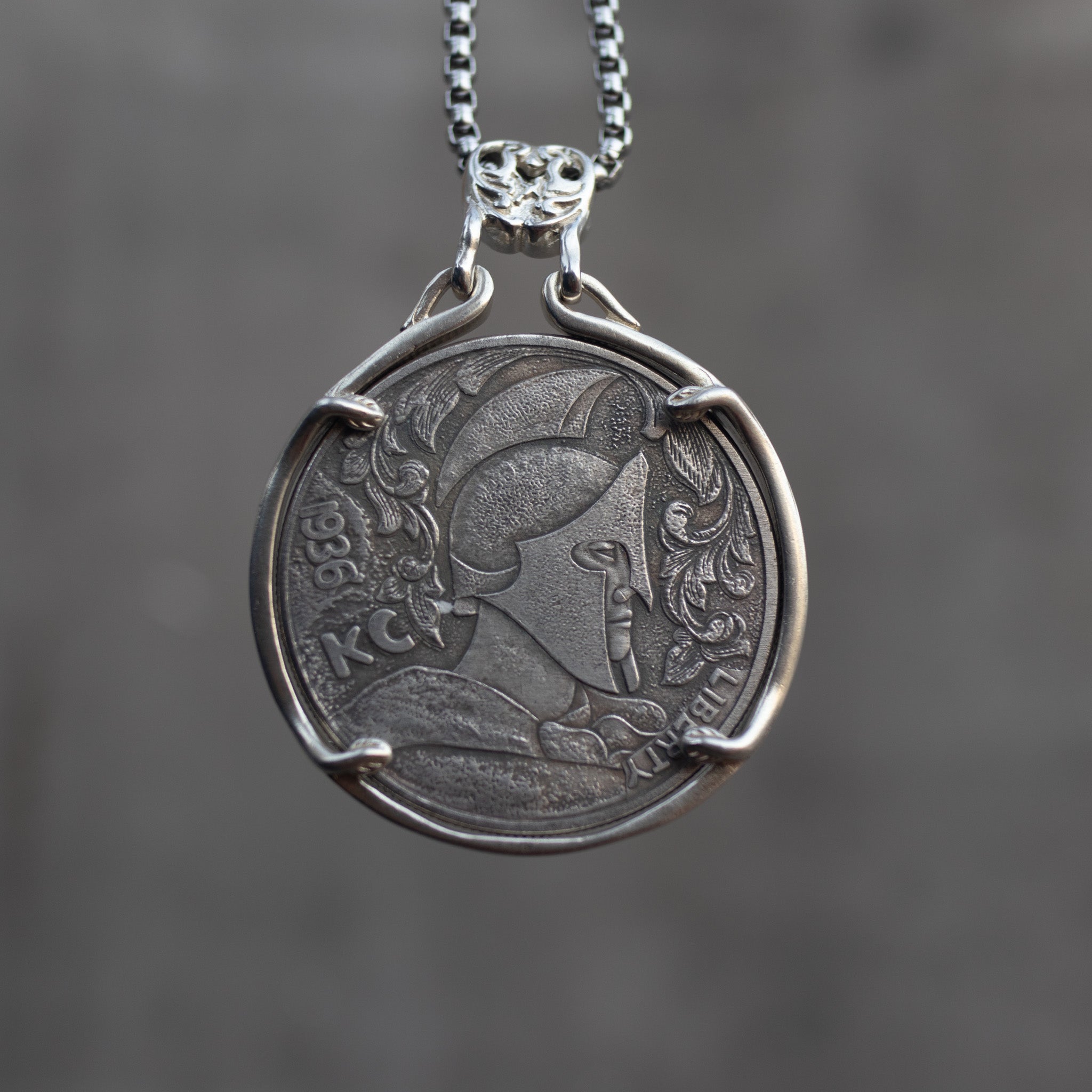 Coin pendant engraved with a Roman centurion in a Corinthian helmet with feathered crest and foliage, Liberty inscription, dated 1936, set in a four-prong bezel on a chain Main image