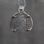 Coin pendant engraved with a Roman centurion in a Corinthian helmet with feathered crest and foliage, Liberty inscription, dated 1936, set in a four-prong bezel on a chain