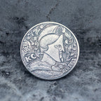 Close-up of a coin engraved with a Roman centurion profile in a Corinthian helmet with nose guard and decorative foliage crest, KC mark, Liberty inscription, dated 1936, on dark stone