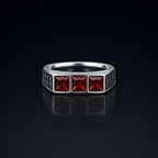 Rune Triple-Stone Signet Ring with three square red garnet stones on a reflective black background