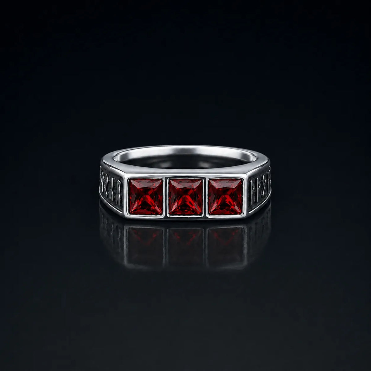 Rune Triple-Stone Signet Ring with three square red garnet stones on a reflective black background