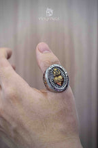 Sacred Heart of Jesus ring worn on the back of a hand — gold flame and crown of thorns motif on a silver oval face, two-tone religious signet ring