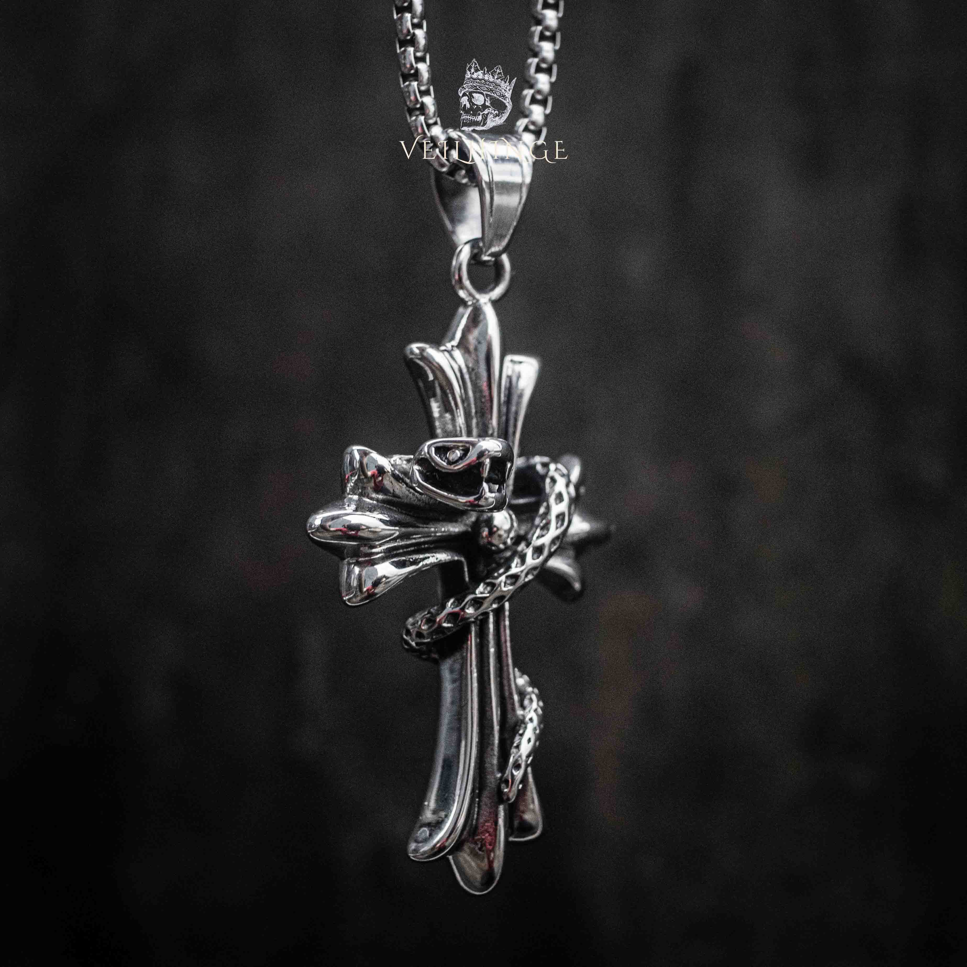 gothic cross pendant with serpent coiled around the shaft — full chain view on dark background