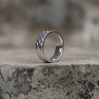 Side view of a silver-tone geometric faceted wide band ring