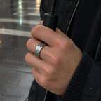 Silver-tone geometric faceted wide band ring worn on the hand