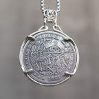 Coin pendant engraved with a skeleton pirate captain holding a lantern beside a ship sail, dated 1921, set in a four-prong bezel on a box chain