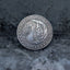 Close-up of a hobo nickel style coin engraved with a skeleton holding a fan of playing cards, flame and feather background, rope border, E Pluribus Unum, dated 1890