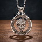 death smiles at everyone skull coin pendant necklace — military beret skull relief, gothic script inscription coin frame, skull bail, antique silver tone, dark wood surface