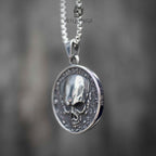 Skull coin pendant necklace side angle view, three-dimensional skull relief, oxidized silver, gothic statement necklace