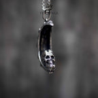 Skull crescent moon pendant necklace side view, three-dimensional skull emerging from crescent moon, oxidized silver, dark aesthetic gothic jewelry