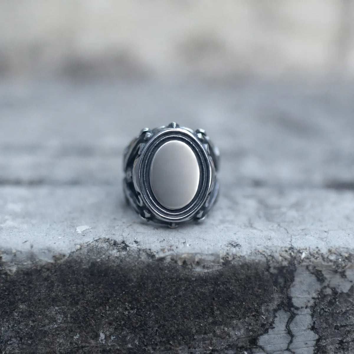 Silver-tone skull signet ring with an oval mirror face, front view