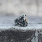 Skull mirror signet ring with ornate scrollwork, shown from the side