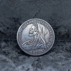 Close-up of a coin engraved with a skull in Queen Victoria's mourning veil, Victoria Dei Gra Britt Regina Fid Def Ind Imp inscription around the border, on dark stone