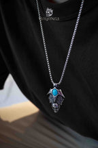 Skull wing pendant necklace with turquoise stone worn on model, oxidized silver gothic necklace, dark aesthetic jewelry