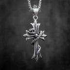 snake wrapped cross pendant front view — serpent head resting at center cross with oxidized dark metal finish