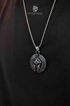 Spartan helmet pendant necklace worn on model, Greek key border coin pendant, oxidized silver, dark aesthetic medieval jewelry