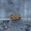 Gold-tone spinner ring with raised sun, crescent moon and star details, front view