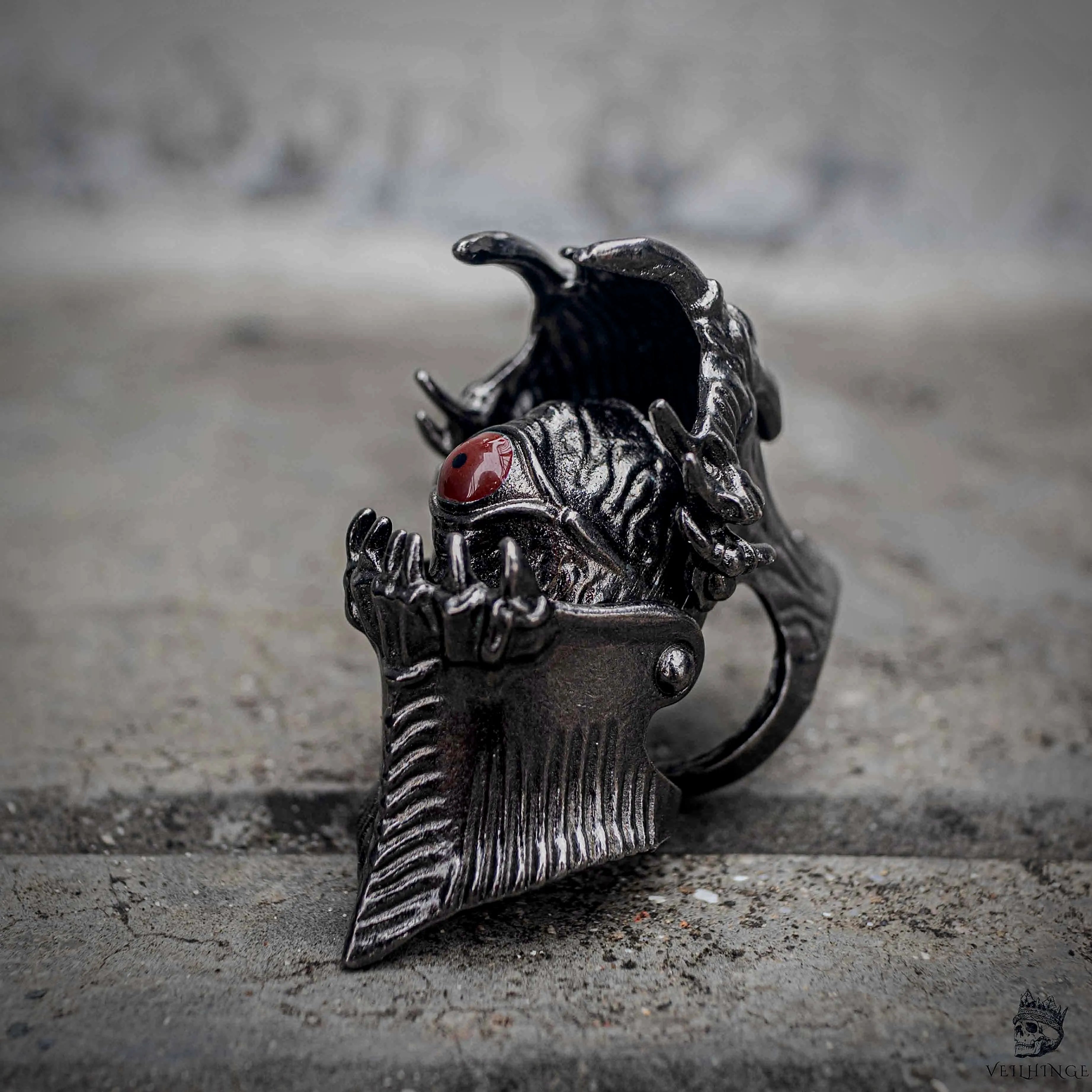 Gothic demon eye articulated ring close-up showing fang jaw mechanism and hidden eye detail in oxidized black stainless steel, dark aesthetic statement ring by Veilhinge, angled view