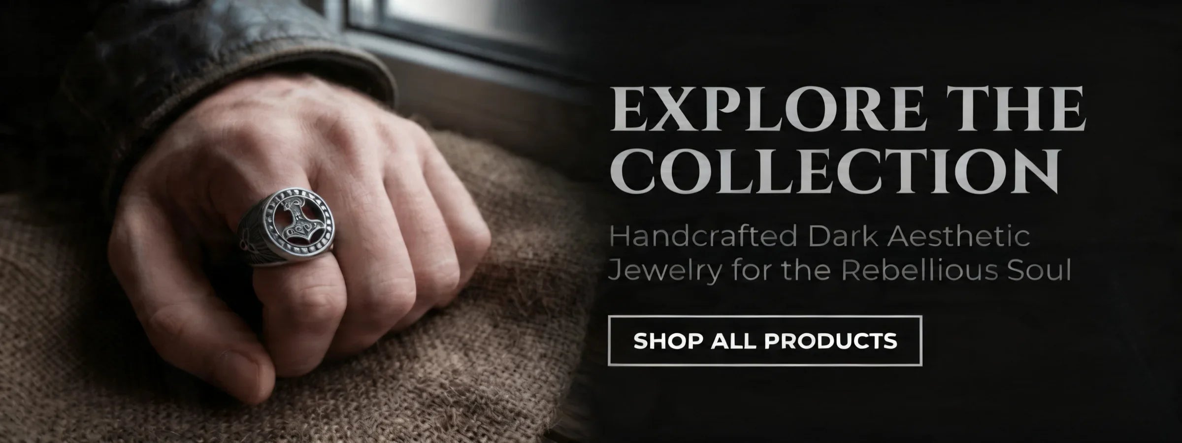 Veilhinge dark aesthetic jewelry all products banner featuring hand wearing Mjolnir Thor hammer ring on rustic wood background