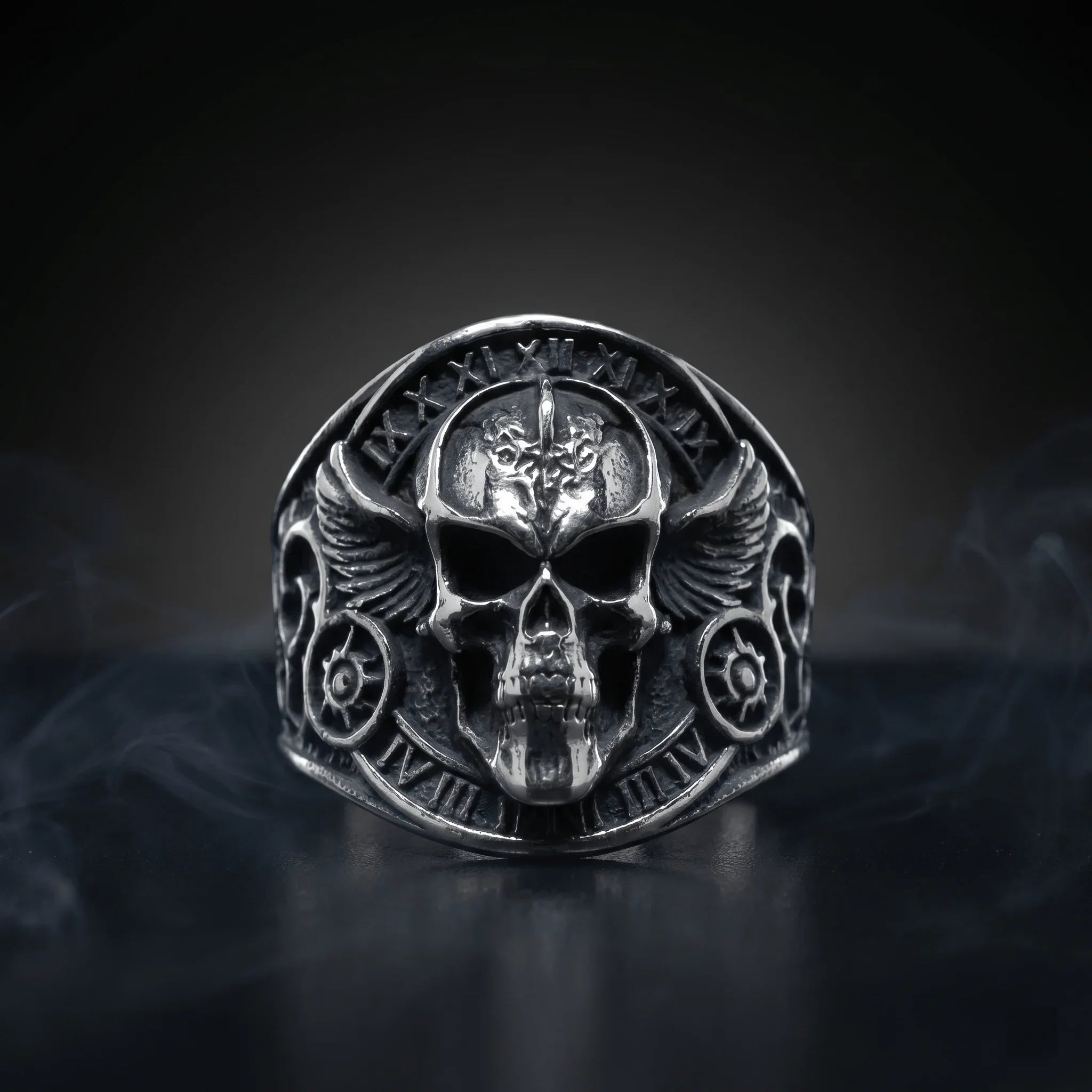 Veilhinge ring collection featuring gothic winged skull ring with Roman numerals in oxidized sterling silver on dark smoky background
