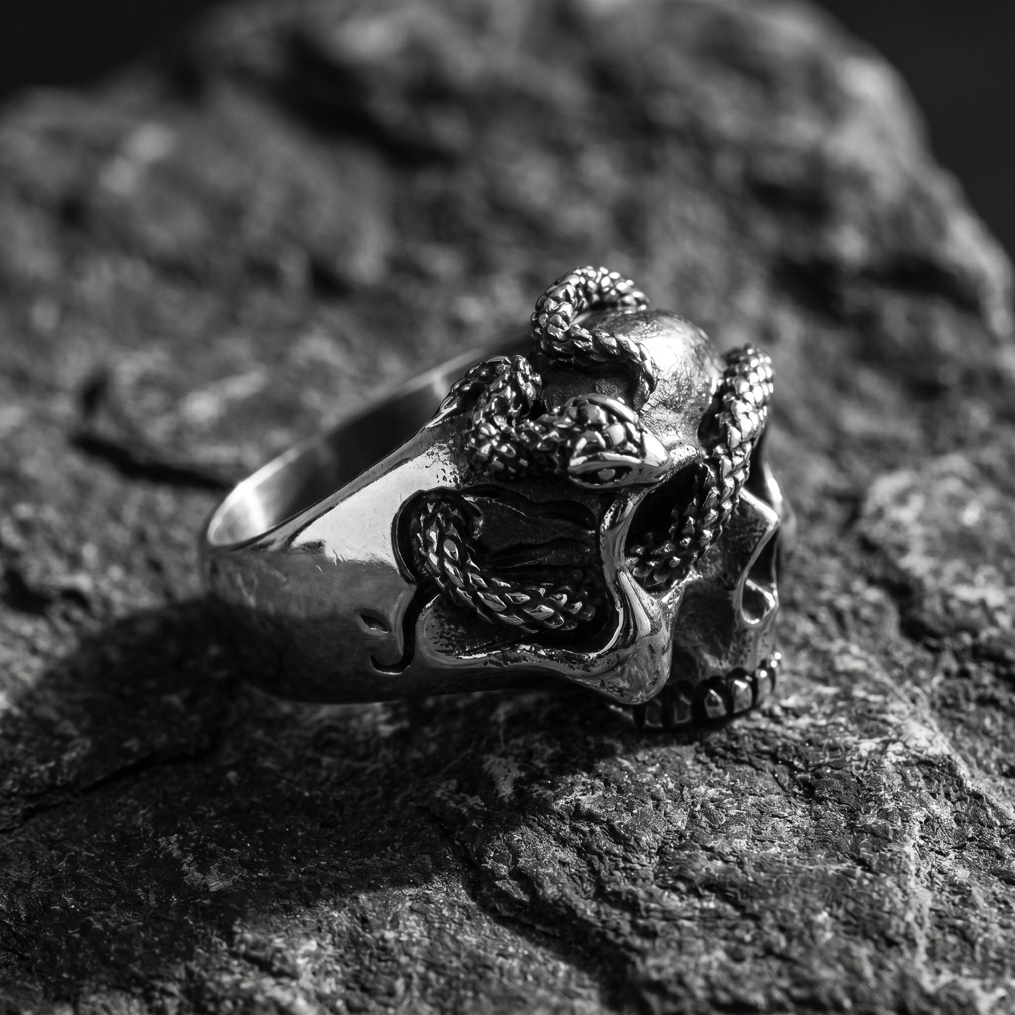 gothic skull ring with snake design metal texture close up