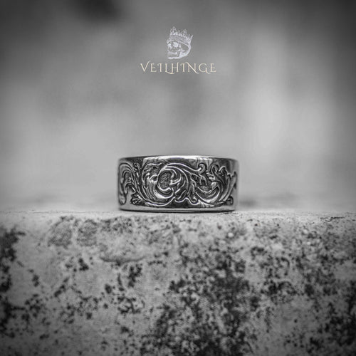 Wide band ring with continuous Victorian floral scroll engraving — oxidized silver finish, acanthus leaf pattern wrapping the full band