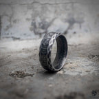 Viking serpent scale ring showing oxidized black wide band with rune engraving and dark polished interior, Norse dark aesthetic stainless steel ring by Veilhinge, angled view