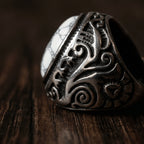 close-up detail of engraved gothic signet ring with white stone