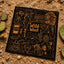 Black bandana laid flat on desert sand showing gold line-art icons including a cowboy hat, Native American headdress, cactus, revolver, and skull with the text Wild West at the center