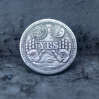 Close-up of the NO face of a decision coin engraved with a winged skeleton above a heart with NO inscription and anchor symbol below